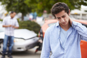 car accident lawyer with a man holding his neck in front of a rear-end car accident